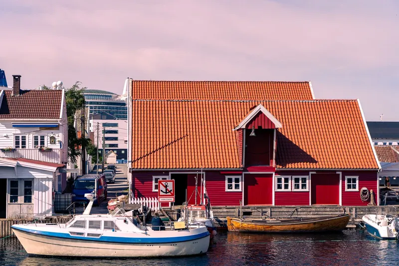 Båter og rødt sjøhus ved Fiskebrygga i Kristiansand