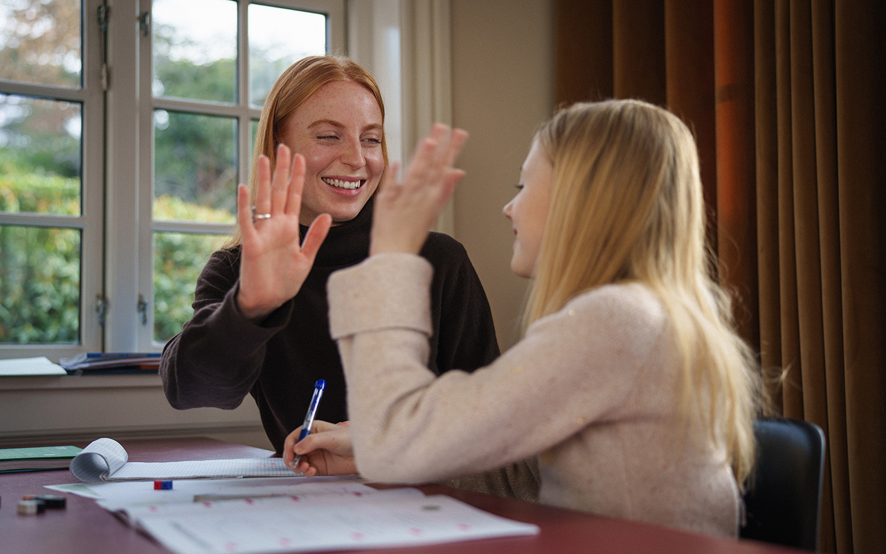 Privatlærer og elev gir hverandre high five